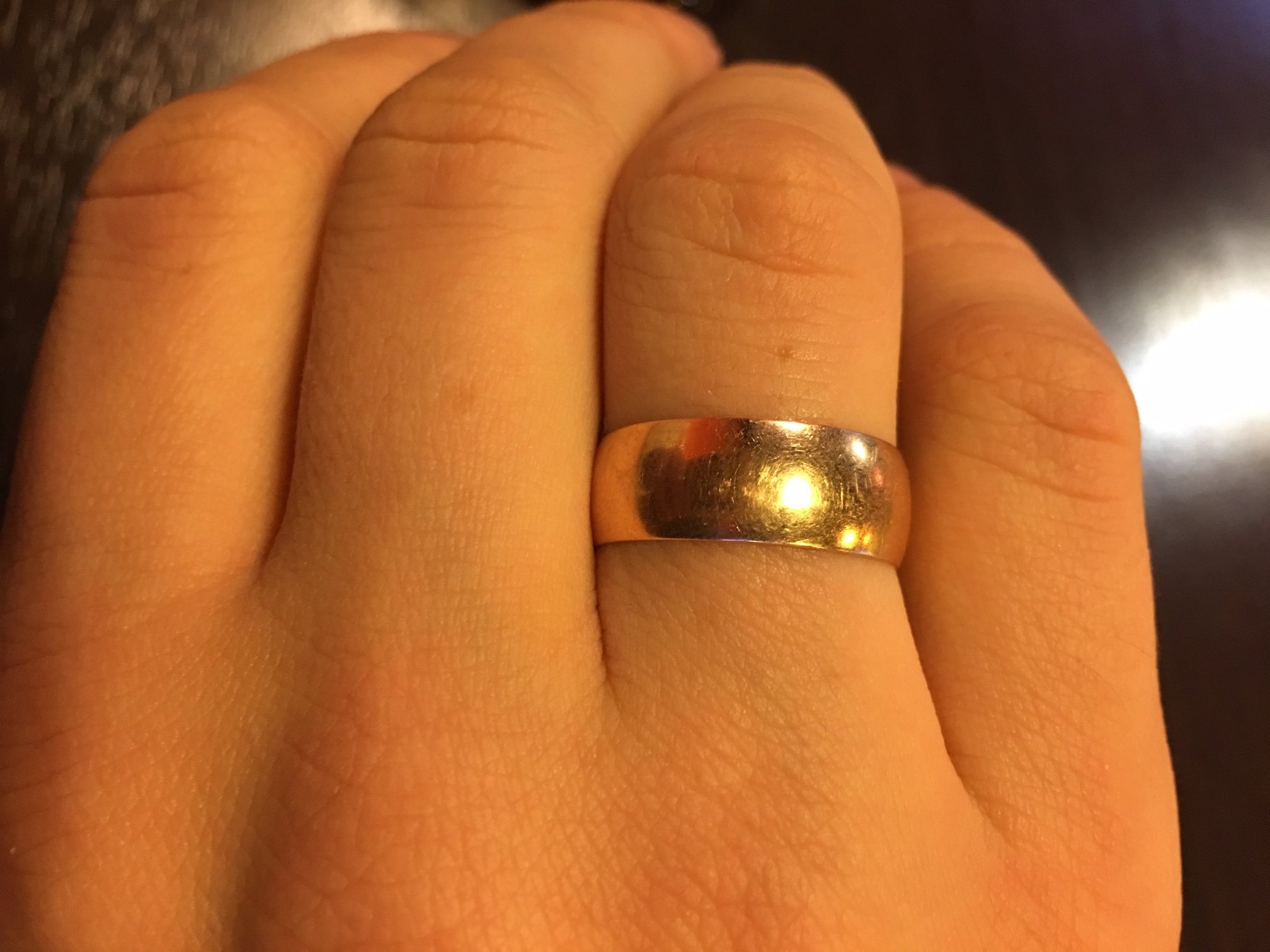 Кольцо оказалось золотым. Широкое обручальное кольцо на пальце. Широкое обручальное кольцо на руке. Широкие обручальные кольца. Толстое обручальное кольцо.